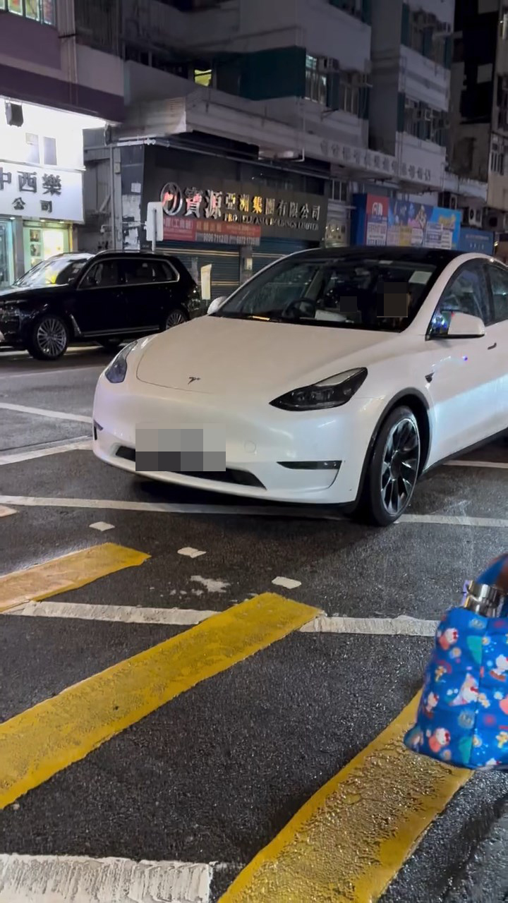 一名男童坐在白色Tesla私家車的司機位上,手握軚盤操控車輛,而旁邊的女乘客未有阻止。網上片段截圖 一名男童坐在白色Tesla私家車的司機位上,手握軚盤操控車輛,而旁邊的女乘客未有阻止。網上片段截圖