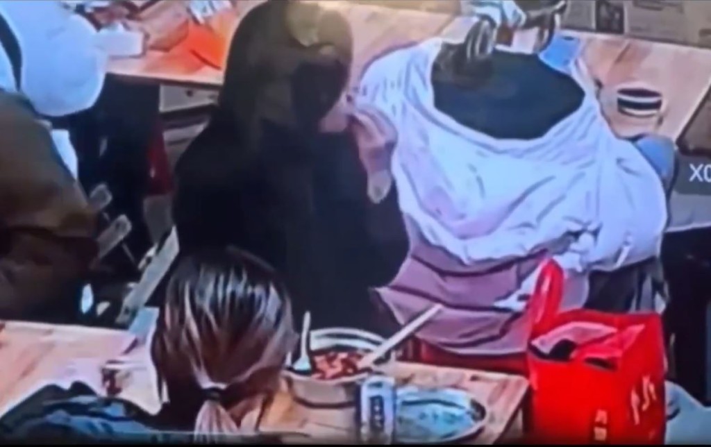 缺德黑衣女將螺螄粉湯倒入背座的羽絨衣帽內。