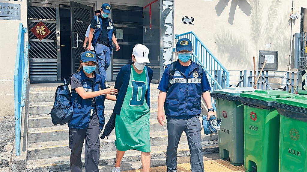 探員將55歲被捕女子押走。