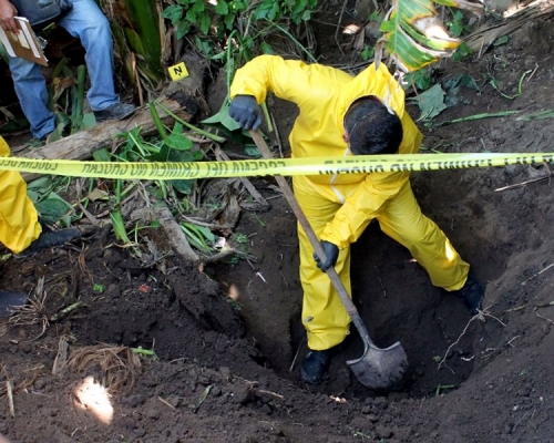 警方继续在乱葬岗搜证。美联社