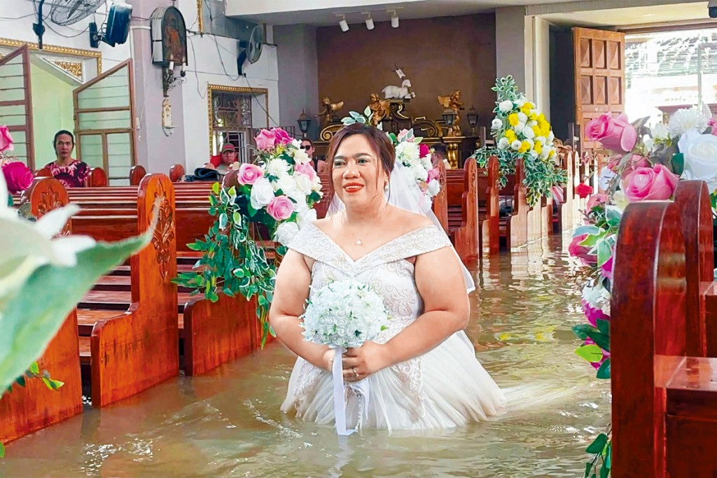 菲律賓哈戈諾伊鎮近日受暴雨侵襲，一間天主教堂嚴重水浸，新娘涉水步入禮堂舉行婚禮。