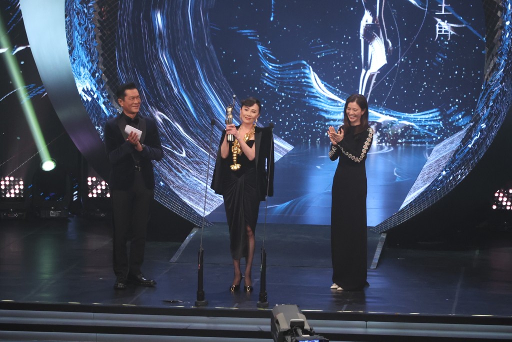 刘嘉玲高举老公梁朝伟「最佳男主角」奖项。