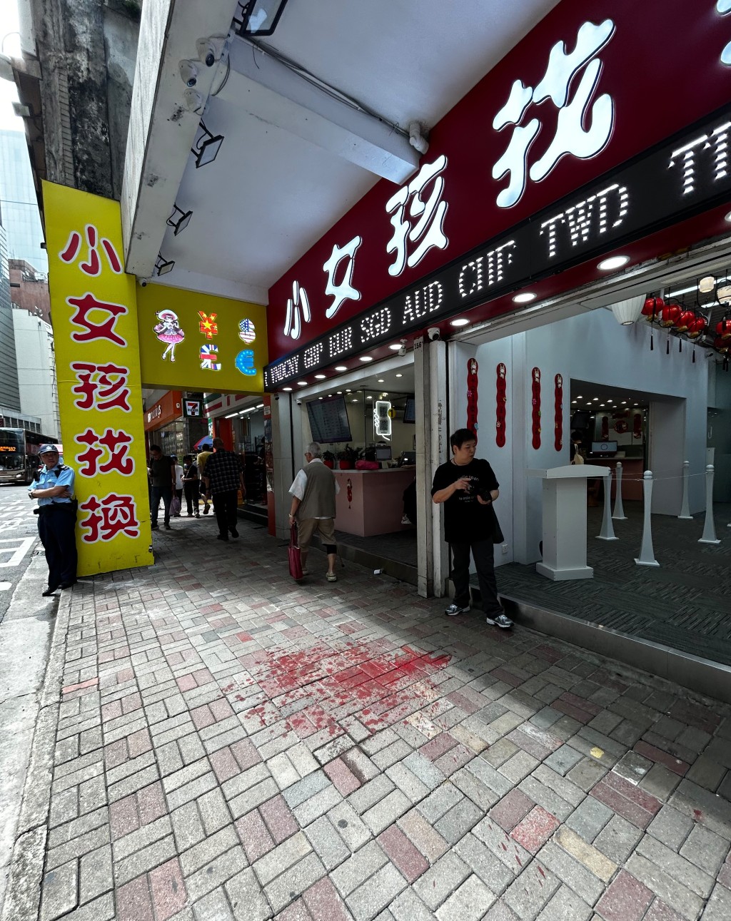 小女孩找換店門外滿地紅色油漆。楊偉亨攝 小女孩找換店門外滿地紅色油漆。楊偉亨攝