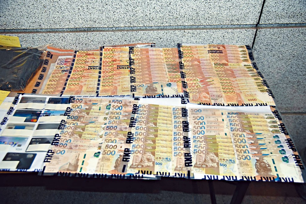 警方展示行動中起出現金及文件等證物。