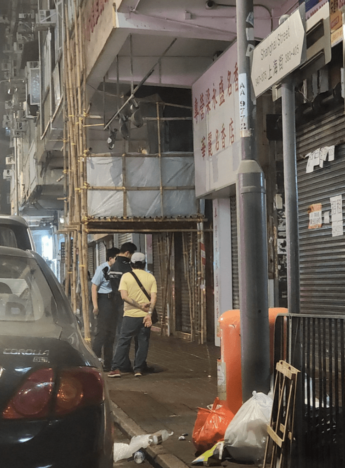 一名63歲男子報稱與白衣女上樓揼骨期間被偷去金鏈，警員在上海街一帶調查。圖中黃衣男子非當事人。黃文威攝