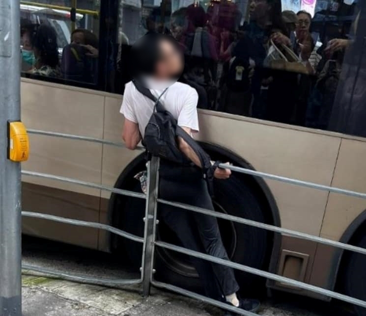 男子被夹栏杆与巴士中间。网上图片