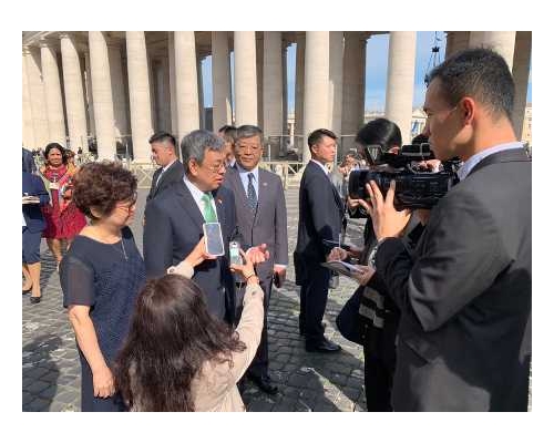 台灣副總統陳建仁（左二）接受媒體訪問時，談到典禮前獲教宗接見的情形。（中央社）