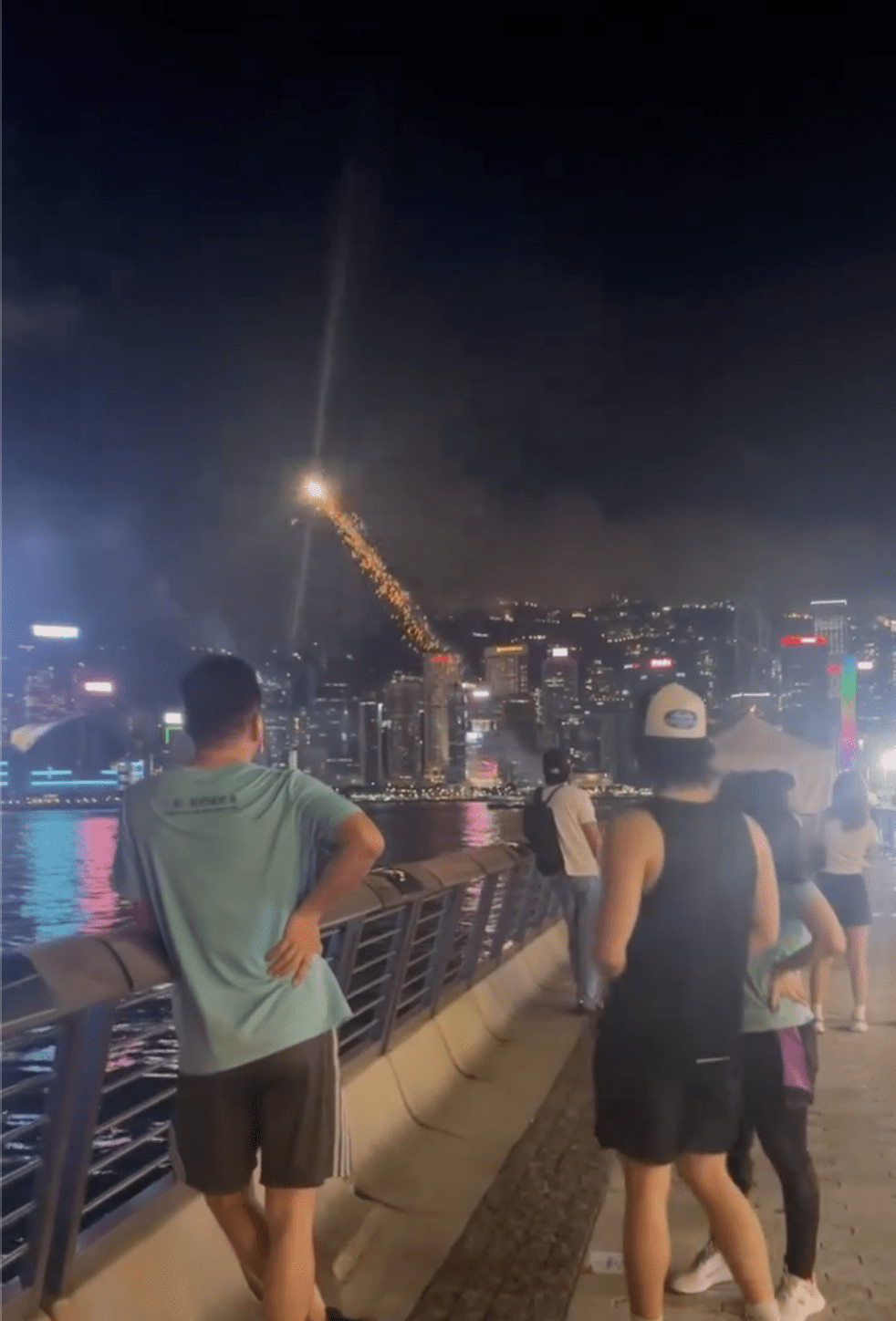 有人在海旁違法燃放煙花,吸引途人圍觀。網上片段截圖 有人在海旁違法燃放煙花,吸引途人圍觀。網上片段截圖
