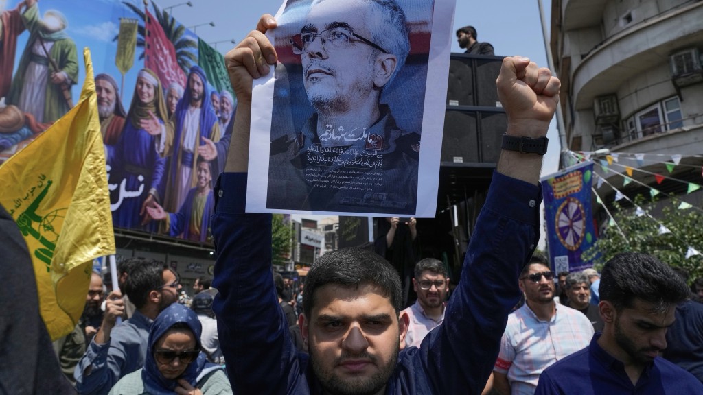 伊朗示威者高舉武裝部隊總參謀長巴蓋里的肖像，巴蓋里在以軍空襲中喪生。 美聯社