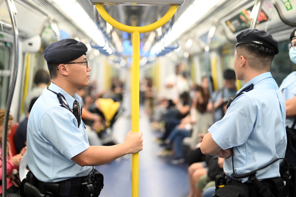 铁路警区人员在港铁列车内巡逻，为乘客提供安全保障。警方供图