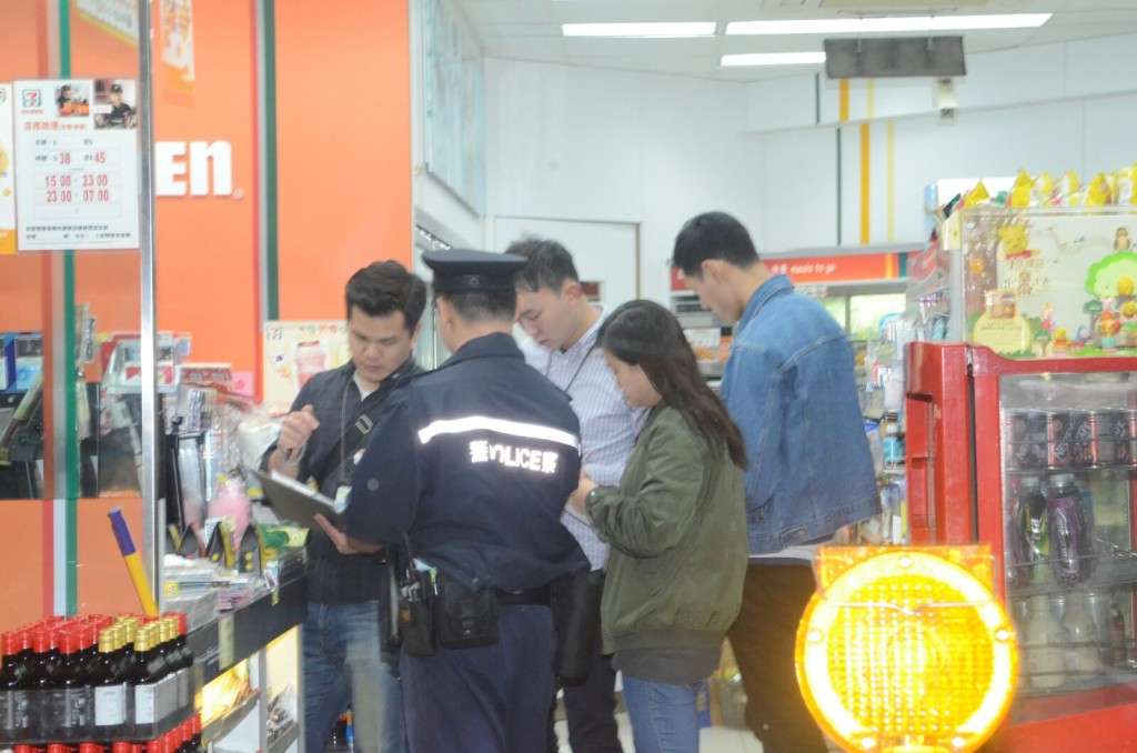 警員在翻看閉路電視,在店舖後巷手推車上發現一個口罩,懷疑為賊人棄下。