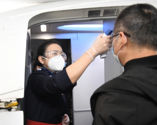 在武漢天河國際機場，乘坐航班的旅客登機前接受體溫檢測。（新華社圖片）