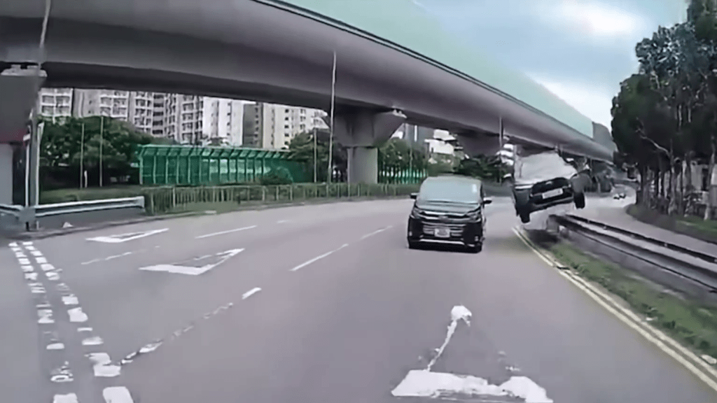 SUV首先撞倒黃色道路標記,然後剷上路中石壆,整車起飛。 SUV首先撞倒黃色道路標記,然後剷上路中石壆,整車起飛。