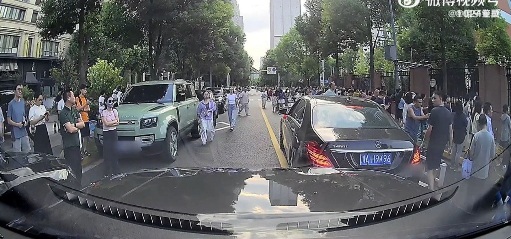 女司機把車停在馬路中間，堵塞後來汽車只為接放學。微博