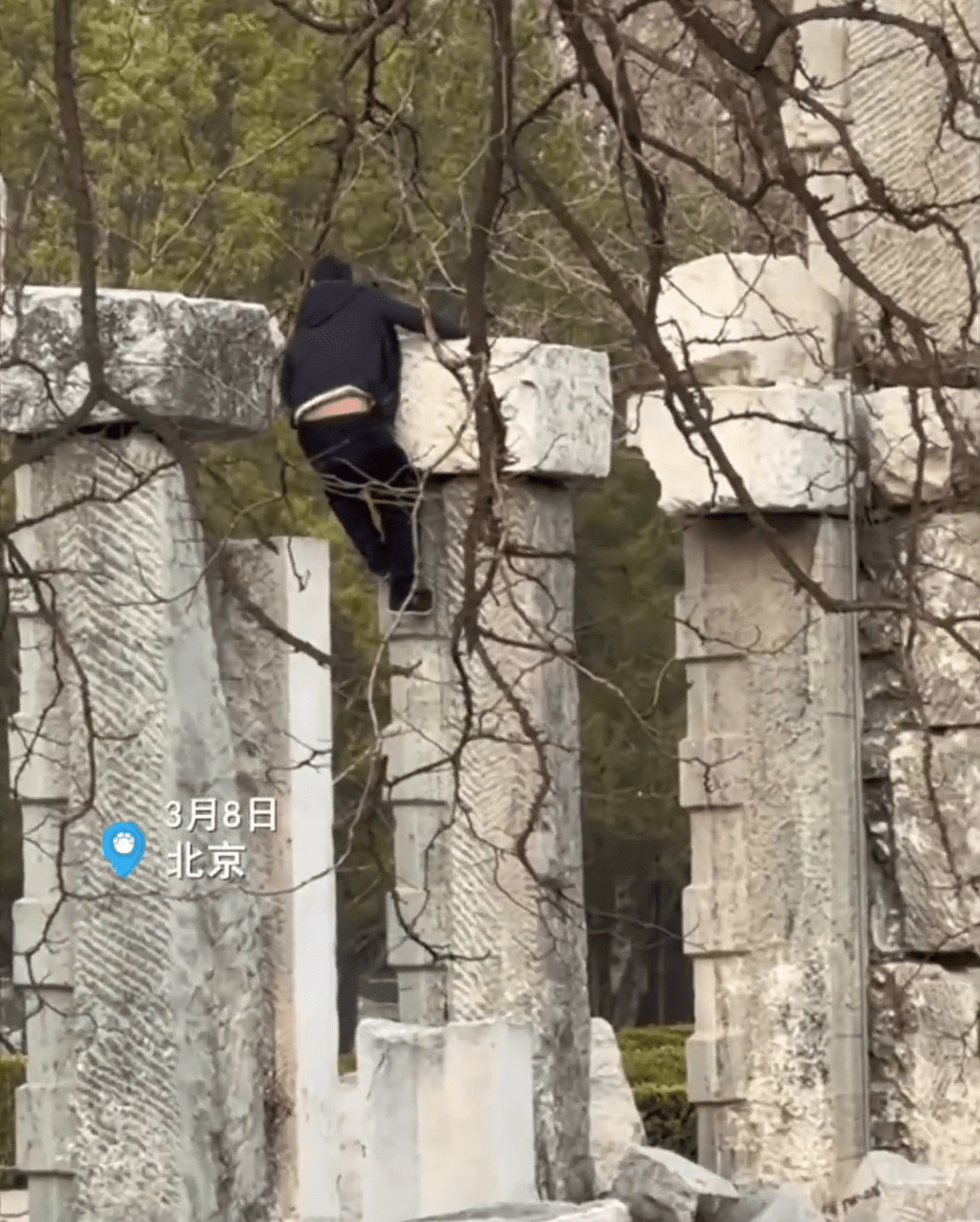 一身黑衣的男子在攀爬遺址建築。