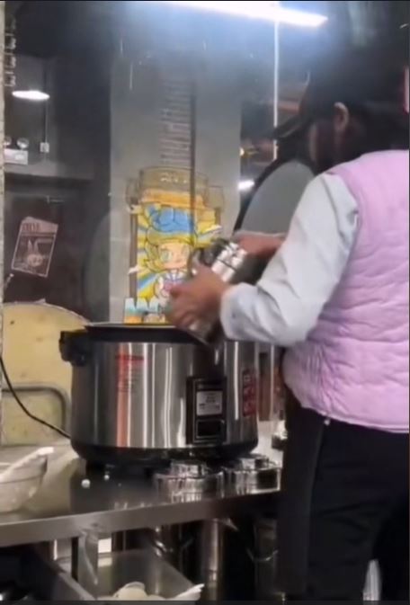 深圳有食店员工将食客吃剩的米饭回收到电饭煲，准备再盛予新客人。影片截图