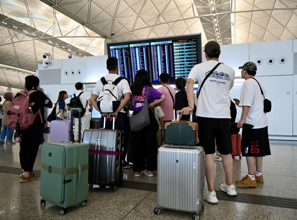 韋帕吹襲香港，市民在機場查看航班資訊。蘇正謙攝