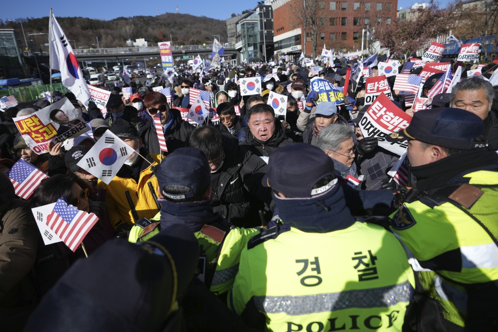 尹錫悅住處外聚集著「挺尹」與「反尹」兩大陣營人馬，警員在場戒備。美聯社