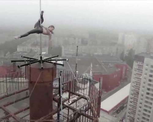 玛琳娜冒着寒冷天气，走到高楼大厦的顶部的天线跳钢管舞。(网图)
