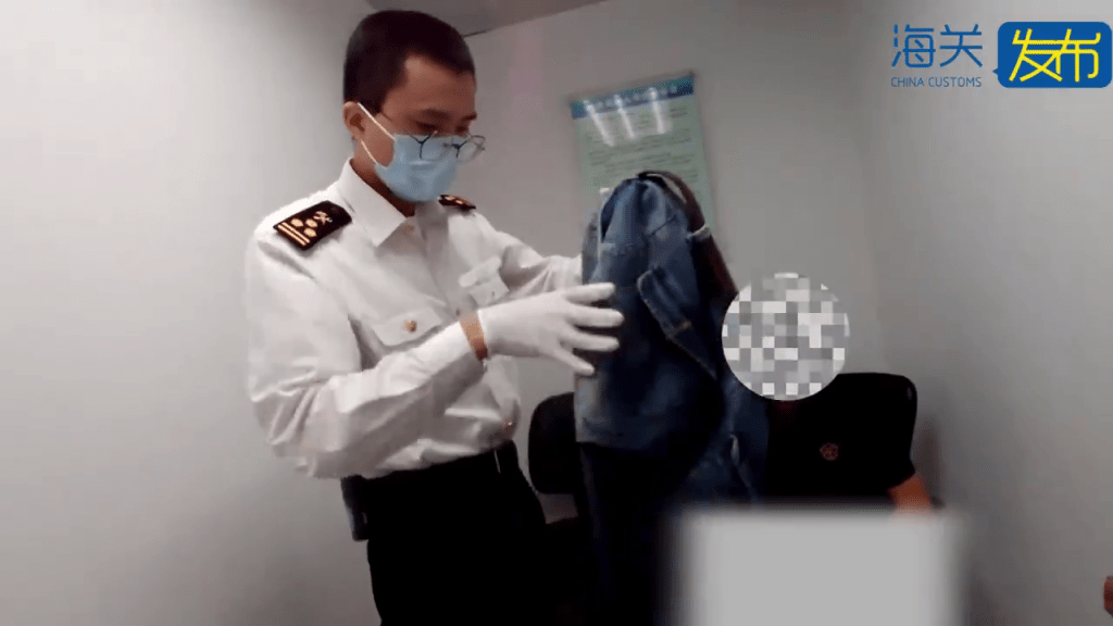 關員搜查可疑男旅客衣物。 關員搜查可疑男旅客衣物。