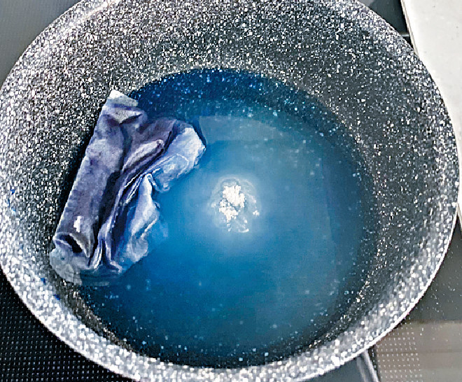 將糖加入熱水，煮成糖漿，然後加入蝶豆花粉，浸出藍色，取起茶袋。