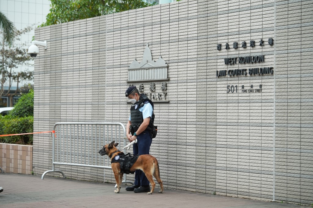 警员带同警犬在法院外戒备。刘骏轩摄