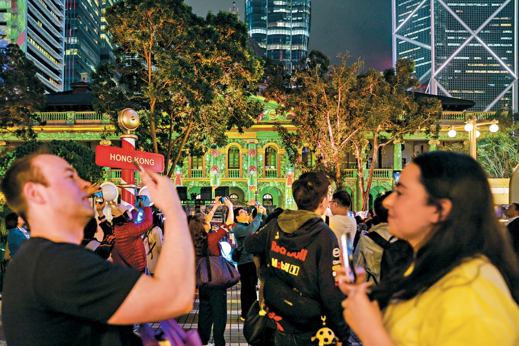 艷麗燈光映照下，有外籍人士興高采烈地拍照。