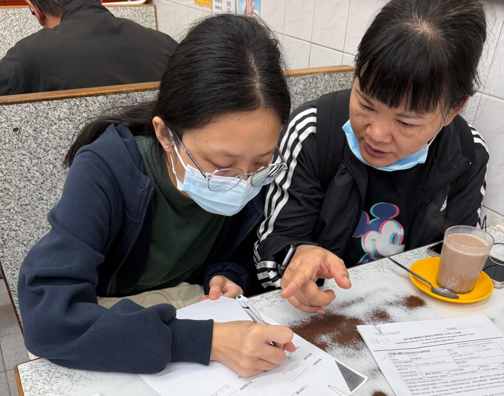 奪命工業意外死者藍秀珍的長女在姨母陪同下簽收「仁間有愛應急錢計劃」善款。 曾志恒攝