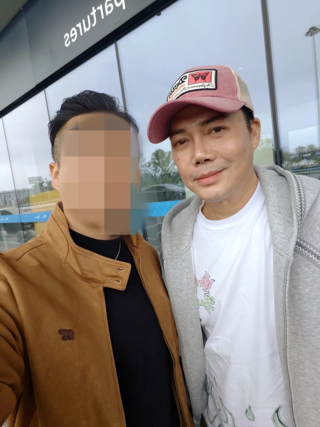 謝天華戴上粉紅色Cap帽休閒現身，親切與同行友人貼面合照。