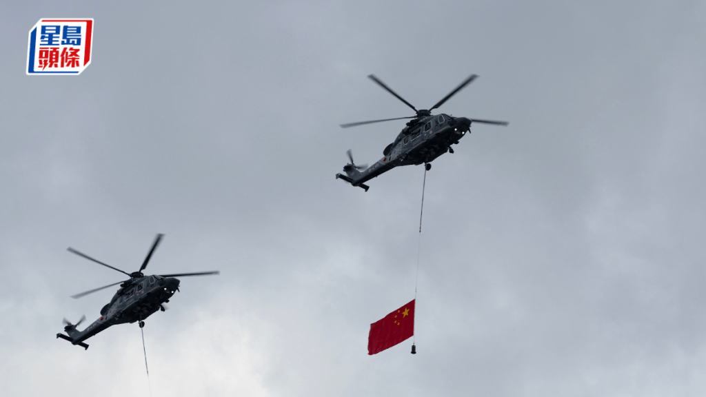 飞行服务队多架直升机分别悬挂国旗及区旗，飞越维港上空。苏正谦摄