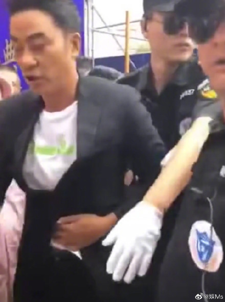 任達華自行步離現場時以手按著腹部。網圖