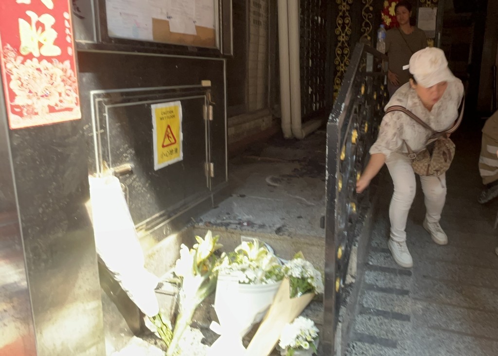 今早仍有街坊在大廈門口擺放鮮花悼念死難者。林思明攝