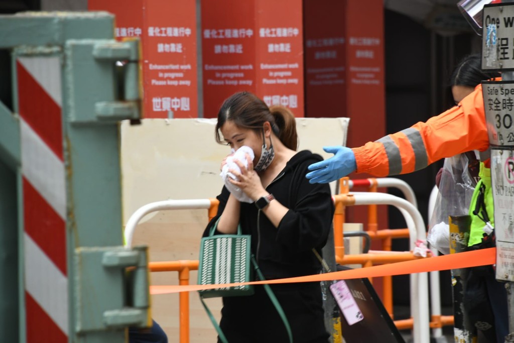 世贸中心市民分批获救至地面，部分人用毛巾掩盖口鼻以免吸入浓烟。
