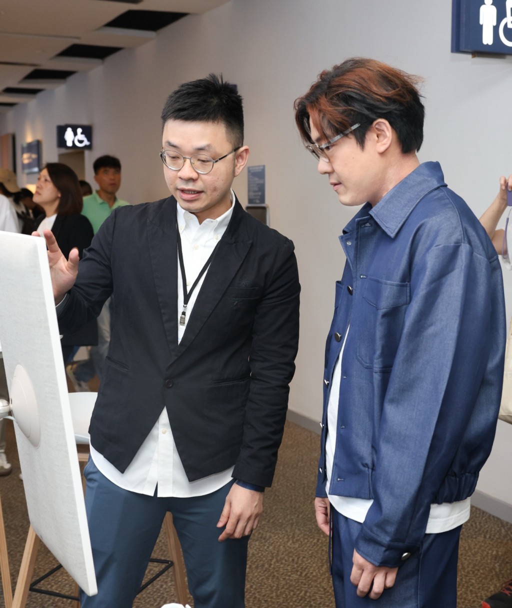 啟豪認真了解全新AI智能歌迷會系統。