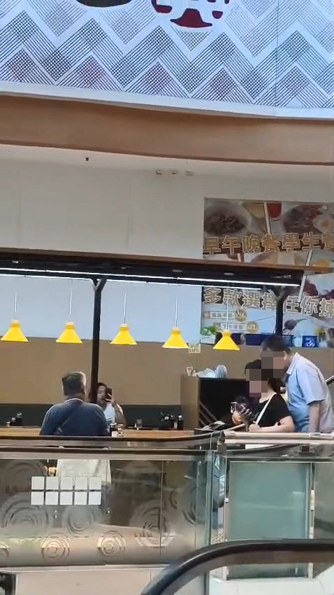 一名男子搭扶手梯時偷聞前方女子的「髮香」。網上片段截圖 一名男子搭扶手梯時偷聞前方女子的「髮香」。網上片段截圖
