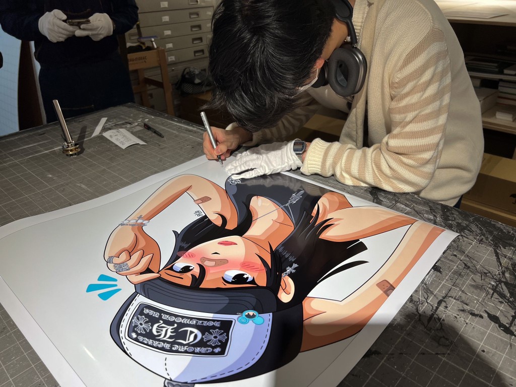 Andrew於展覽現場為自己的作品簽名。