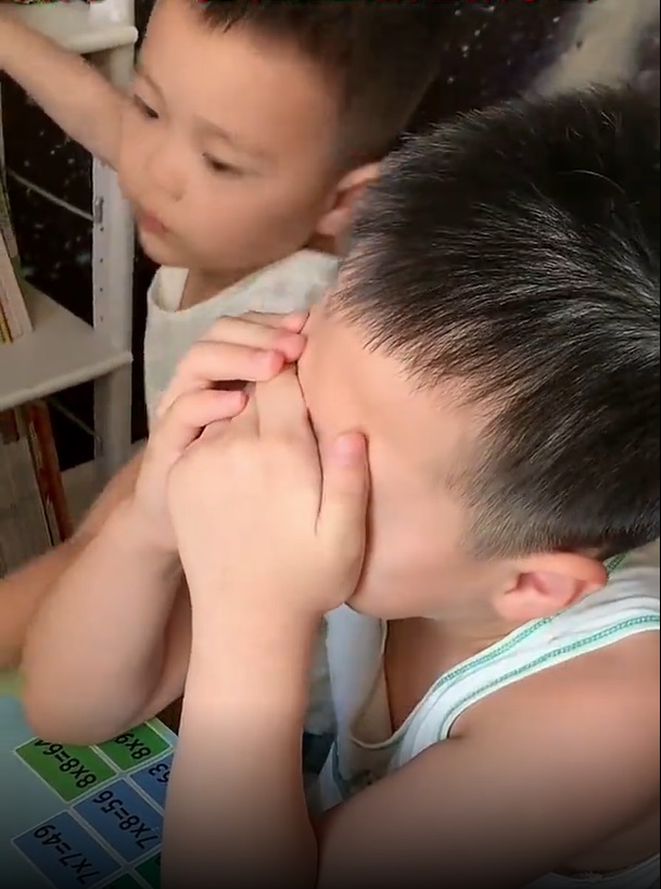 哥哥生氣到哭而弟弟卻伸手去弄旁邊的書櫃。網上截圖