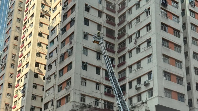 消防架起云梯在单位外射水救火。