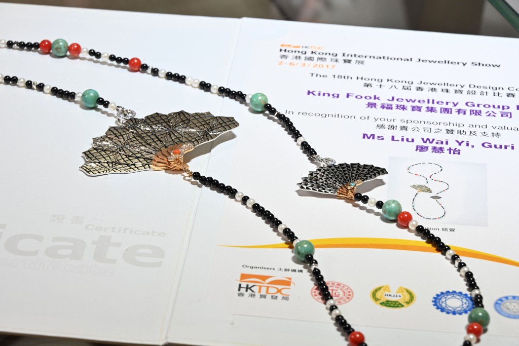 參與第十八屆香港珠寶設計比賽的獲獎作品「錯覺」，以富有東方色彩的扇為主題的多元寶石長項鏈，扇子部分可自由開合。