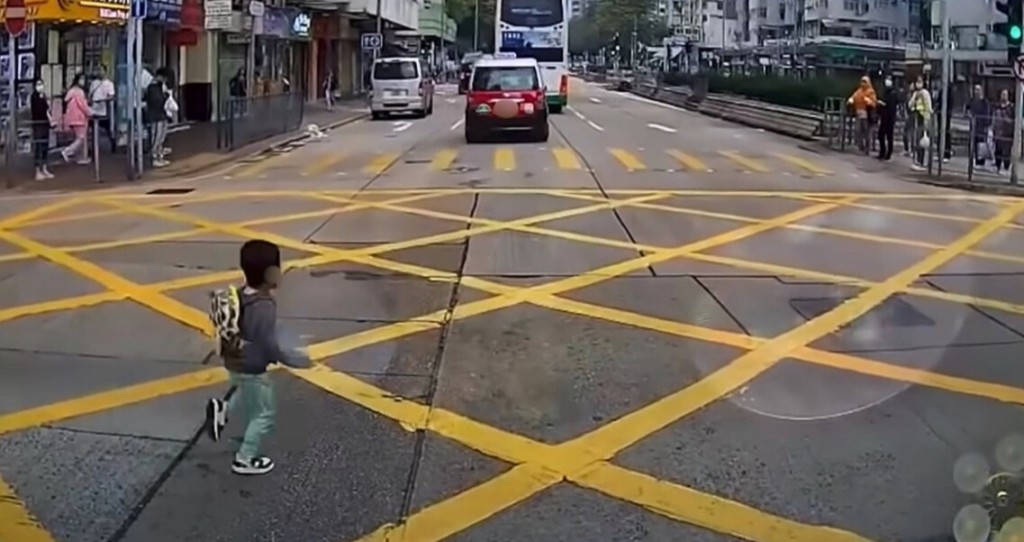 橫過馬路時家長稍一鬆懈,隨行小朋友便出現險象。(來源:網上影片截圖) 橫過馬路時家長稍一鬆懈,隨行小朋友便出現險象。(來源:網上影片截圖)
