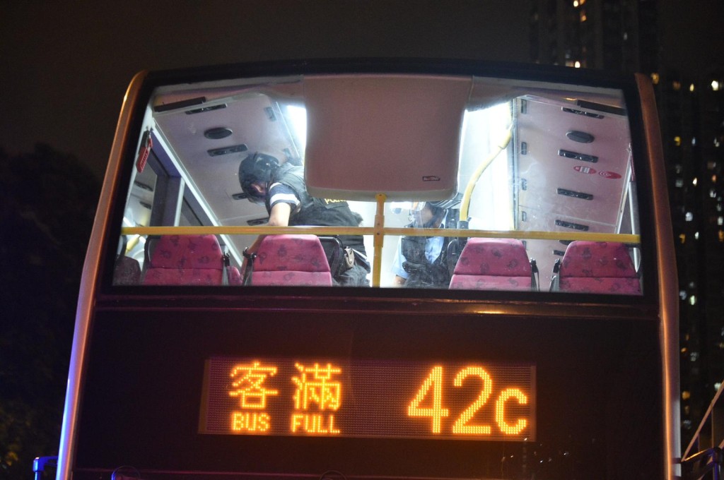 防暴警察在晚上9時半左右於九龍灣港鐵站外截停一輛巴士