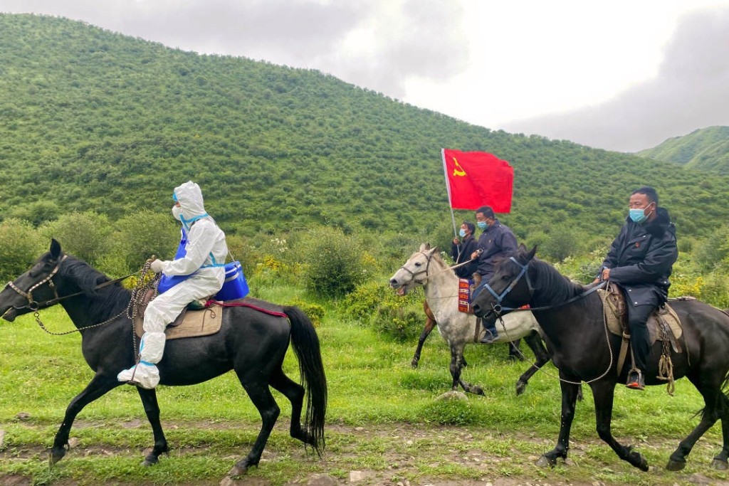 防疫人员骑马进入甘肃高原牧场进行核酸检测任务。