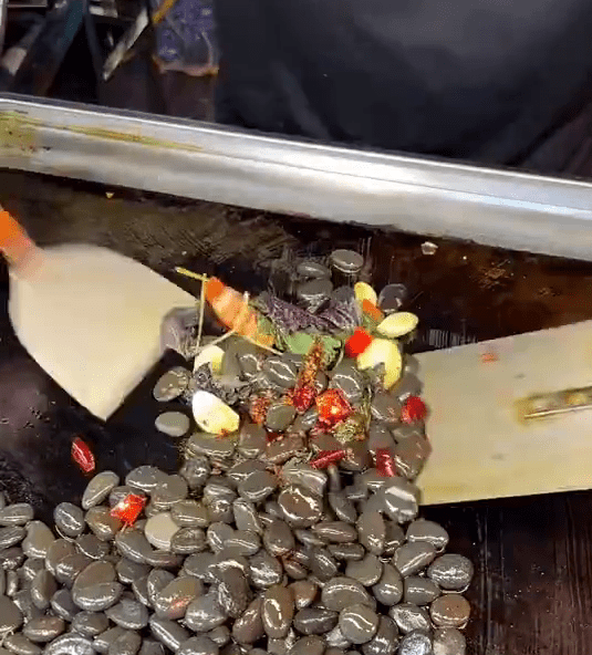 长沙夜市惊现16元一份的「爆炒鹅卵石」，拍摄者不禁问「能吃吗？」。网上截图