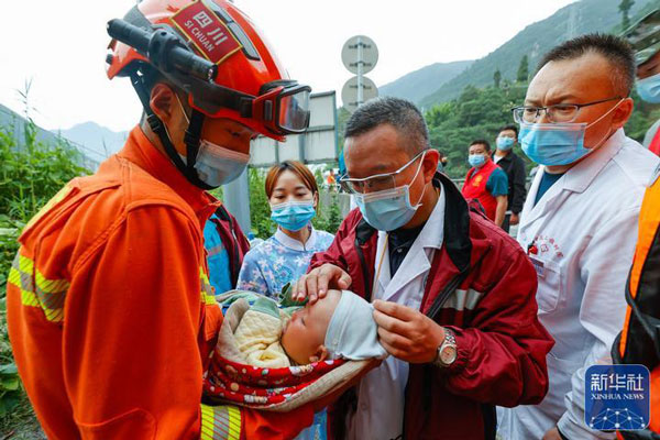 張自立將嬰兒交給到災區救援的醫生照顧。