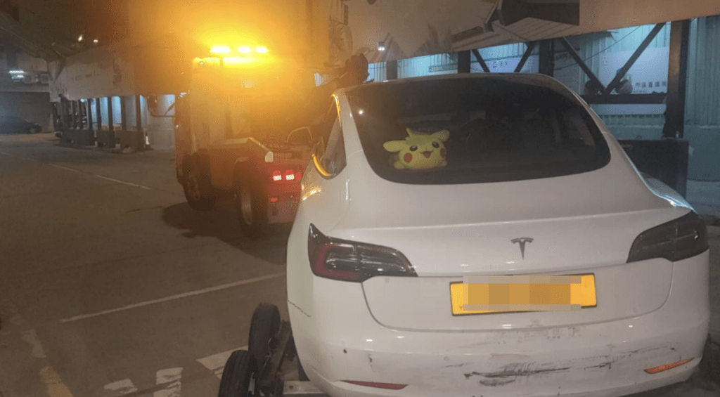 Tesla被拖走，車尾有明顯擦花痕迹。黎志偉攝