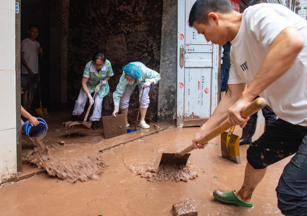重庆市洪水退去后居民开展清淤工作。中新社