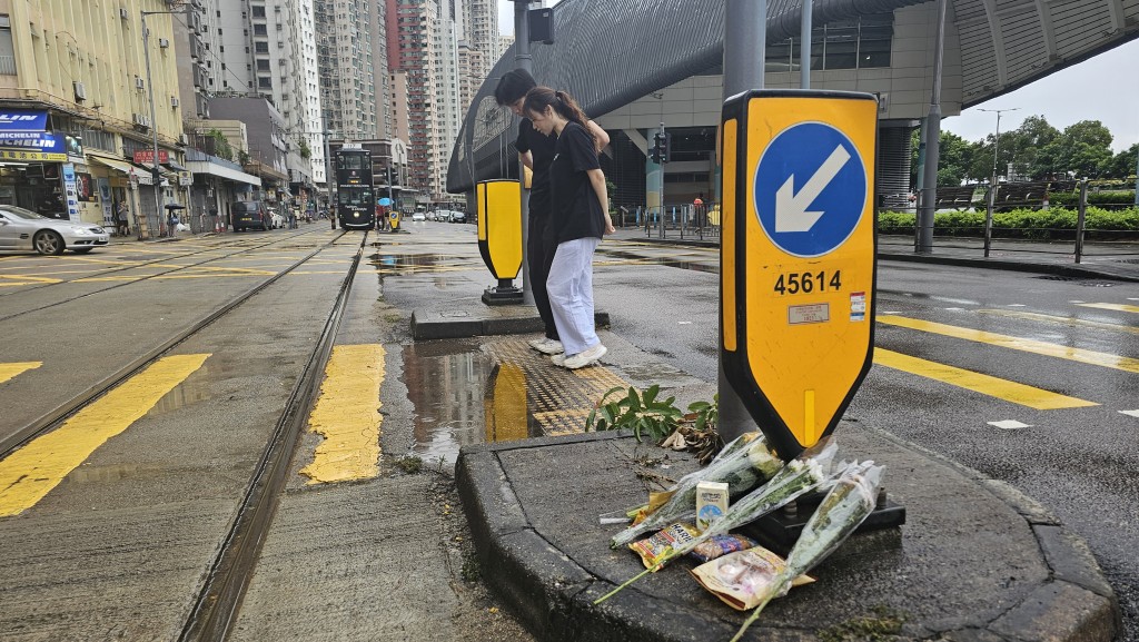 咖啡店的職員天仔及陳小姐，下午在安全島位置獻上鮮花及糖果。徐裕民攝