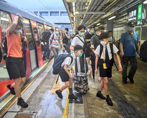 學生們早上冒雨上學。
