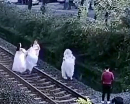 內地近日有一名男攝影師與4名女子，竟跑到火車鐵軌上拍婚紗照。影片截圖