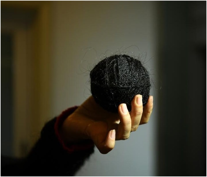 婦人在展示整理編織頭髮的方法。